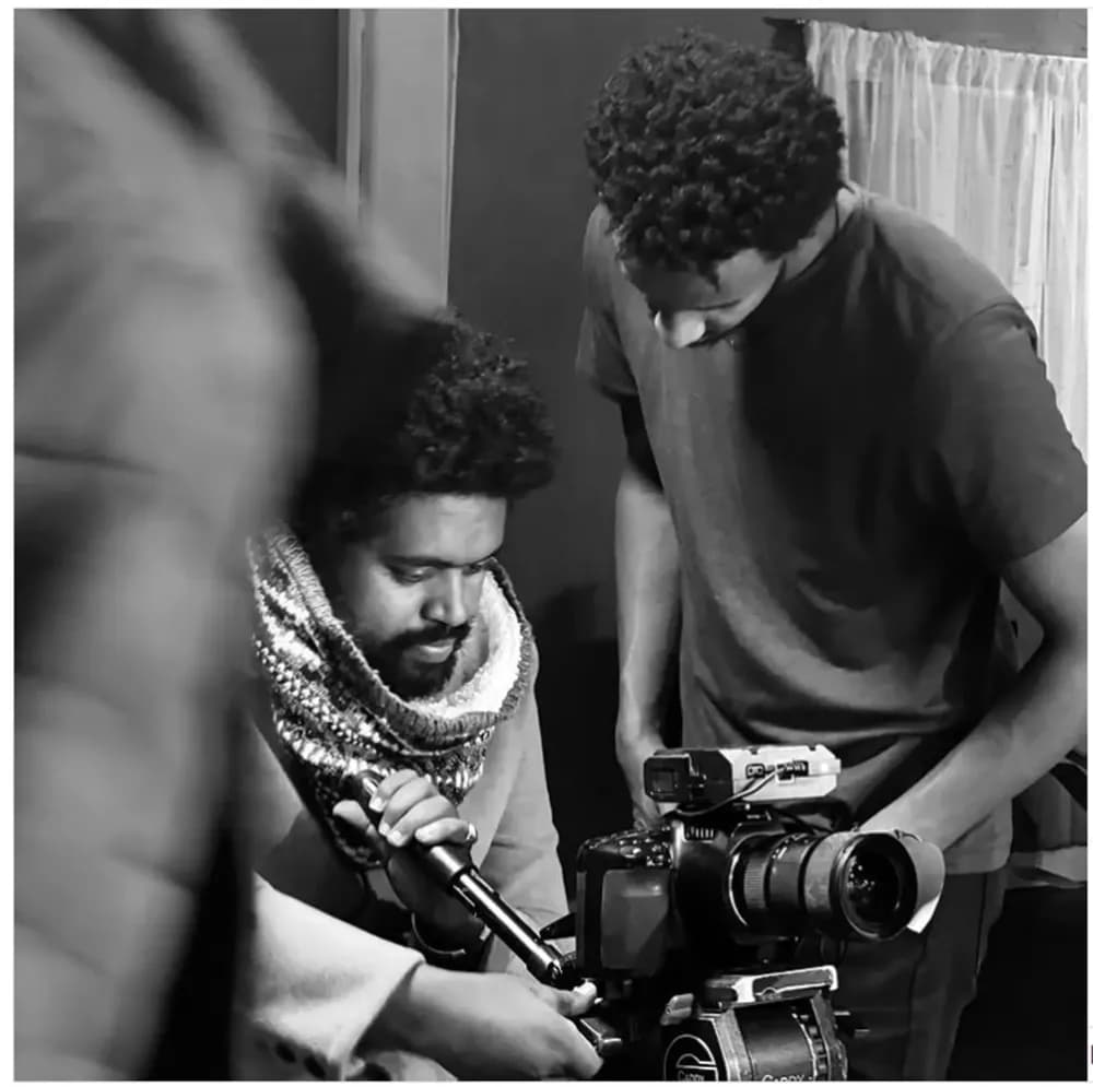 Walk into Sewmehon Yesmaw’s workplace, and you’ll instantly feel the creative hum. Cameras and lights scatter across the room, a lush garden peeks outside, and on the wall hangs a striking portrait of Professor Haile Gerima, his artistic idol.